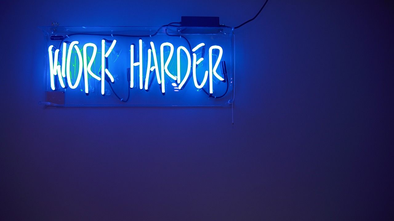 A blue wall and a sign saying 'Work Harder'