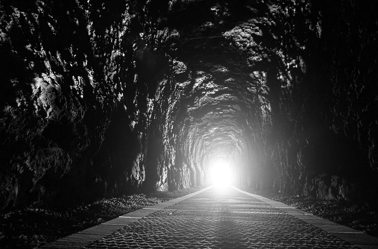 A dark tunnel with a bright light off in the distance.
